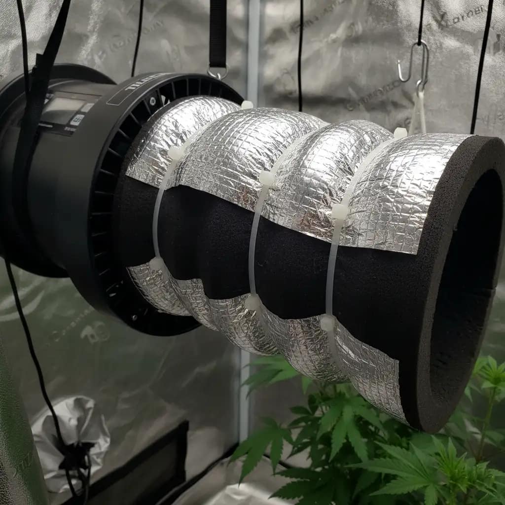 Close-up of an inline fan with DIY insulation wrap on the ducting to reduce noise in a hydroponic tent.