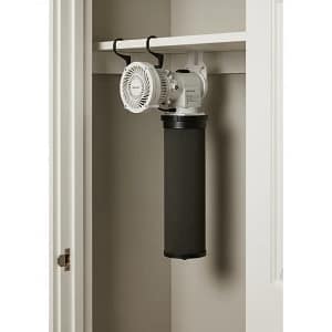 A carbon filter and fan setup inside a closet for odor control in an apartment hydroponic system.